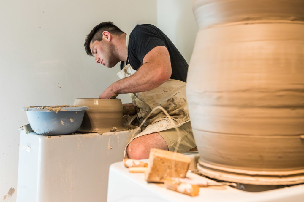 Shane Lutzk, artista americano in residenza artistica presso il museo della ceramica di Savona, lavora al al tornio per modellare parte del proprio vaso